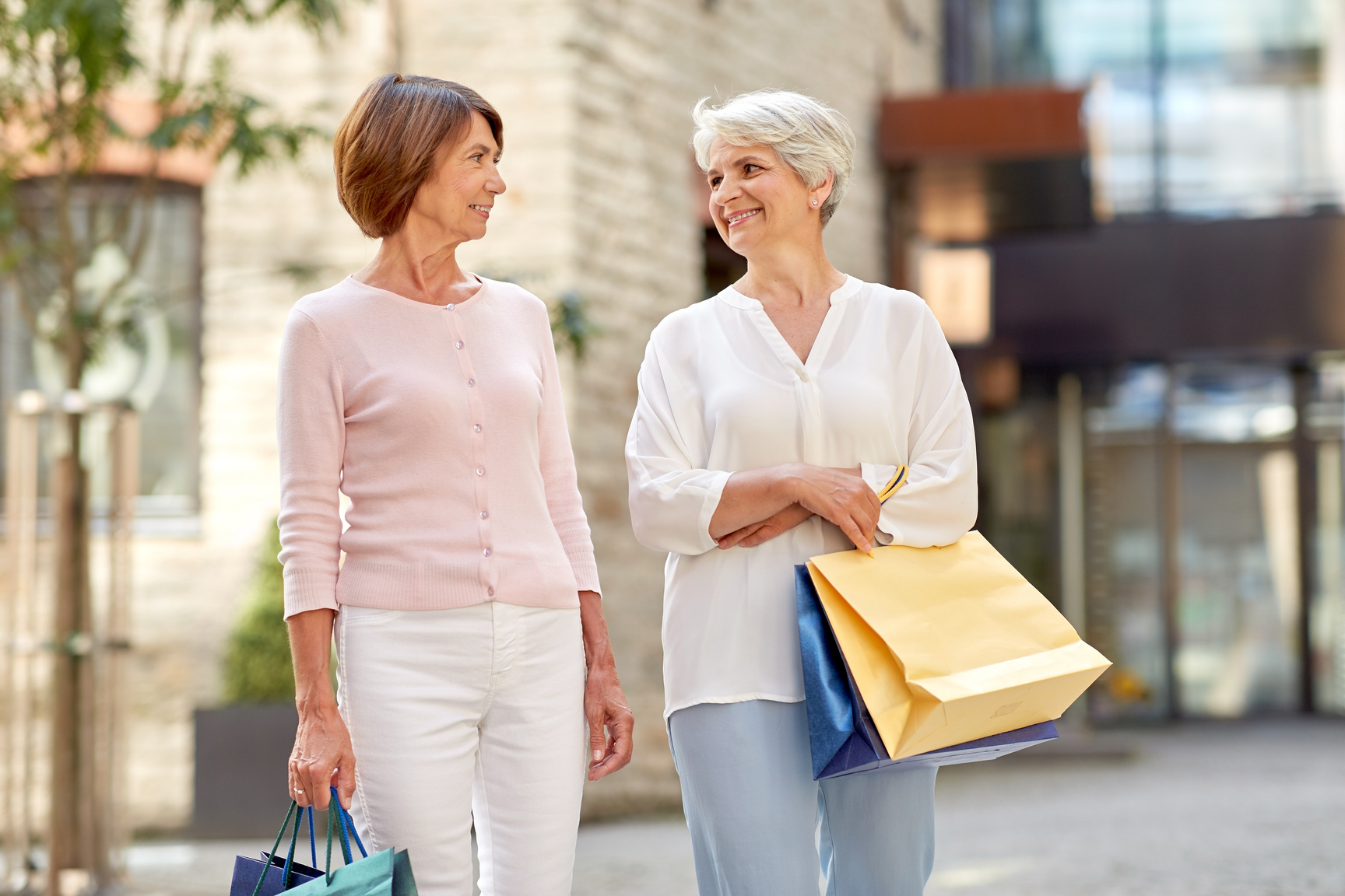 Senior Women with Shopping Bags Walking in City